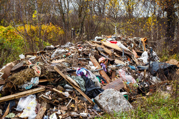 A colossal heap of household junk and construction debris dumped in an autumn forest, highlighting rampant environmental pollution and neglect