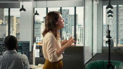 Coworkers broadcasting an advertising vlog for business marketing, reviewing documentation and analytics. Professional office highlights data visualization and forecasting within corporate. Camera B. - Powered by Adobe