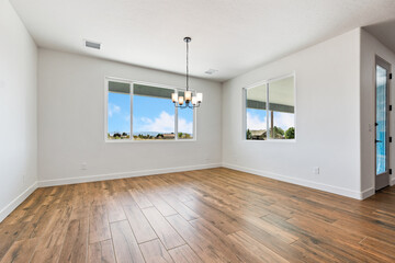 A spacious living room with hardwood flooring and a stunning chandelier