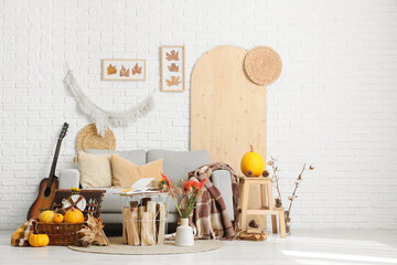 Interior of living room with sofa, picnic basket and autumn decor