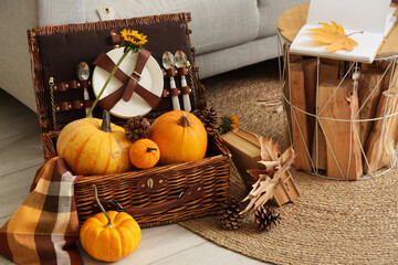 Picnic basket with pumpkins in living room