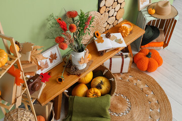 Vase with autumn flowers, decor and books on bench in room