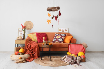 Interior of living room with sofa, tables and autumn decor