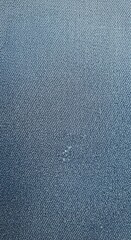 Close-Up Detail of Blue Jeans Fabric with Subtle Wear and Small Damage Spot