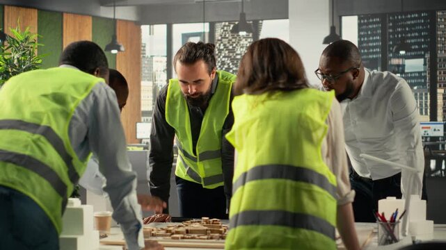 Real estate professionals using architectural software to refine housing layouts and 3D models. Development team collaborates on zoning regulations and property investment strategies. Camera B.