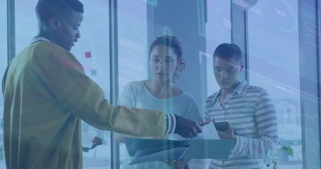 Colleagues in business attire analyzing data in glass office, with sticky notes, documents, tablet