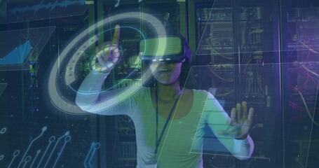 Manipulating holographic interface wearing VR headset at data center, with server racks and cables