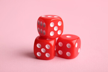 Red game dices on pink background