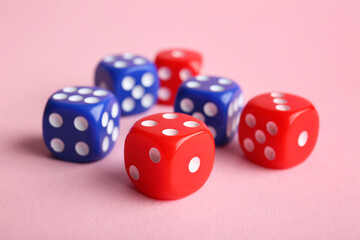 Different game dices on pink background, closeup