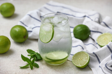 Glass of lime infused water with mint leaves on white background, closeup