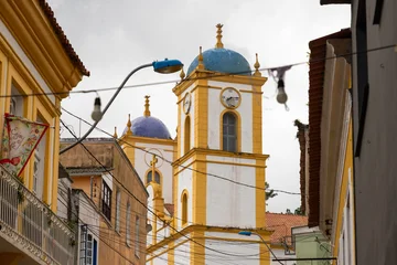 Selbstklebende Fototapeten Enge Straßen Tower of an old church seen between narrow streets in a historic Brazilian town  © nikopacheco
