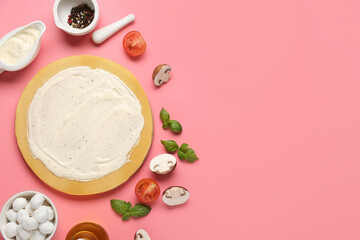 Pizza dough with tasty sauce and ingredients on pink background