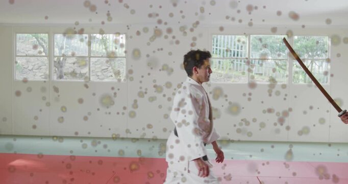 martial arts instructor in gi blocking blue gi bokken strike, redirecting wrist lock for control