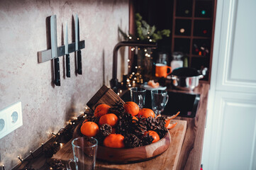 rustic kitchen features a wooden table with bright oranges and pine cones, creating a warm...
