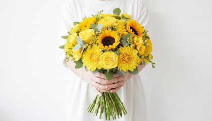 黄色の花束を持つ女性の手元