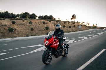 Fototapeta premium red Motorbike Riding on Road at Sunset – Adventure Lifestyle Concept