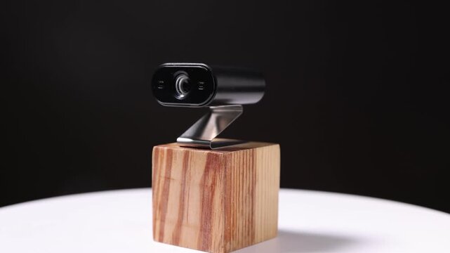 Presentation of hidden spy camera on black background, spinning