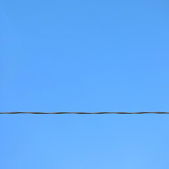 Power line against clear blue sky