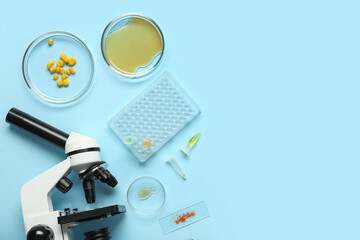 Modern microscope and petri dishes with samples on blue background. Nobel prize day celebration