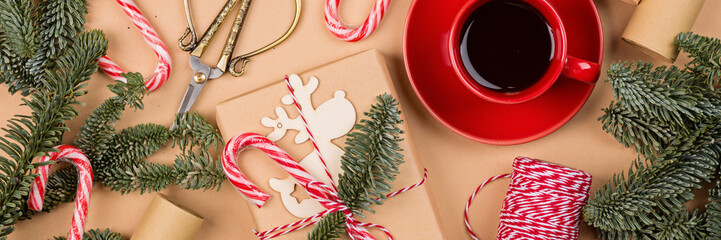 Christmas composition. gift box wrapped in craft paper, fir tree branches, candy canes. new year concept. Greeting card, xmas celebration 2026. Flat lay, top view, copy space, mockup