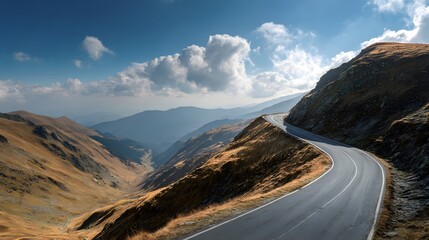 Winding paved route traverses high mountain pass under expansive blue sky