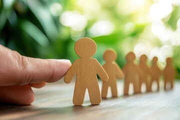 Teamwork and Leadership: A hand carefully positions a wooden figure amidst a lineup, symbolizing leadership, teamwork, and the importance of individual contribution in achieving a shared goal. 