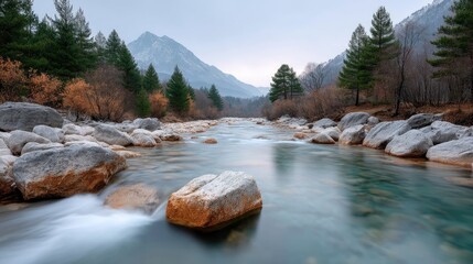 Rushing mountain river with rocky edges and snow dusted trees under a soft sky in a natural landscape