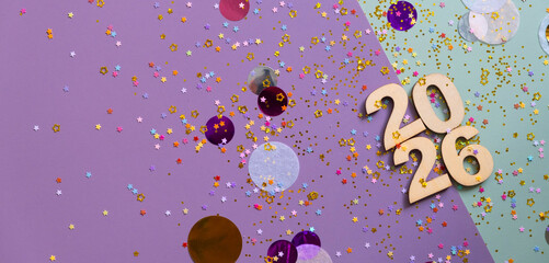 Wooden numbers 2026 on colourful surface with golden glitter