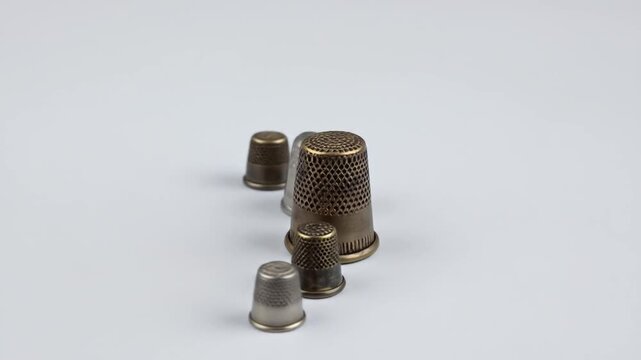Assortment Of Antique Thimbles Displayed Against A Clean White Background With Subtle Shadows