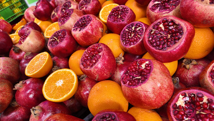 Colorful display of pomegranates and oranges at a market
