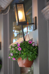 Hanging flower pot with lantern in a cozy outdoor setting