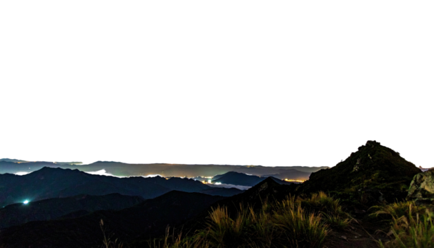 Night panorama of mountain range lit by distant cityscape lights