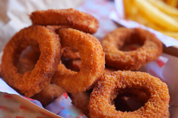 Crispy fried onion rings served in a takeout box