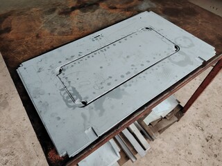 Laser or plasma cut steel plate with etched lines and rectangular cutout.