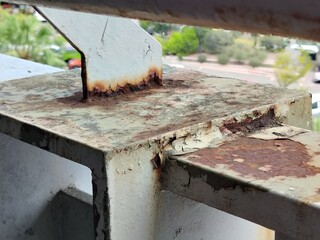 Corrosion damage, detail of oxidized steel and peeling coating on a building component.