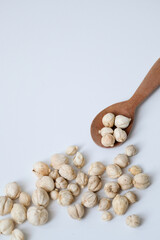 Dried white cardamom in a wooden spoon isolated on white background