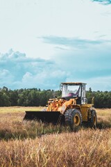 Obraz premium Outdoor Medium Shot Yellow Wheel Loader Construction Equipment in Field