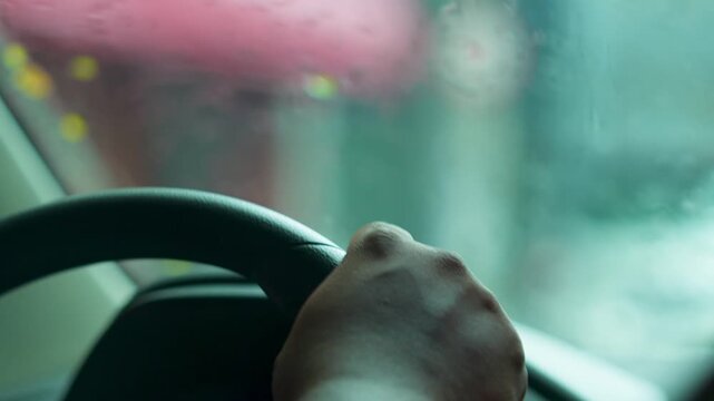 Homem negro dirigindo na chuva | Black hand on car steering wheel, close-up, safe driving