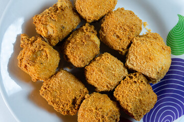 Close-up of crispy golden fried tofu cubes on a plate. Traditional Asian snack with crunchy texture, perfect vegetarian street food served hot and freshly fried