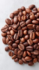 Fototapeta premium Rustic Flat Lay Overhead View Of Roasted Coffee Beans Scattered On A Light Gray Textured Surface With Soft Natural Lighting Highlighting Bean Details And Rich Brown Tones