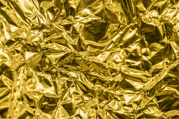 Luxury shiny metallic golden foil crumpled texture background