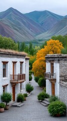 Whitewashed Tibetan Village Landscape with Colorful Autumn Trees and Majestic Mountains Under Cloudy Sky