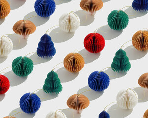 Colorful Paper Christmas Ornaments as round balls and Christmas trees, hanging eco-friendly New Year decorations. Minimal aesthetic holidays pattern, top view background of winter baubles.
