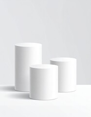 Three white cylinders in ascending heights on a white surface