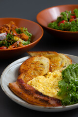 Traditional breakfast plate with scrambled eggs, Bacon, Sourdough and Mix Salad.