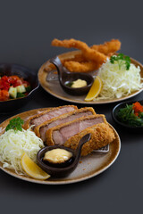 Japanese deep fried pork or tonkatsu set with Japanese deep fried shrimp on grey background.