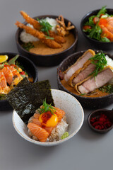 Salmon Donburi with Tonkatsu Curry rice, fried shrimp Curry rice and Salmon salad on grey background.