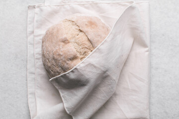 Overhead view of homemade artisan bread on a white countertop, top view of baked sourdough artisan bread on a white background