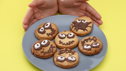 Cookies decorated with chocolate spiders, candy eyes. Concept of Halloween celebration, fun baking, and sweet childhood moments. 