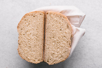 Overhead view of sliced homemade artisan bread on marble countertop, top view of cross-section of sourdough artisan bread